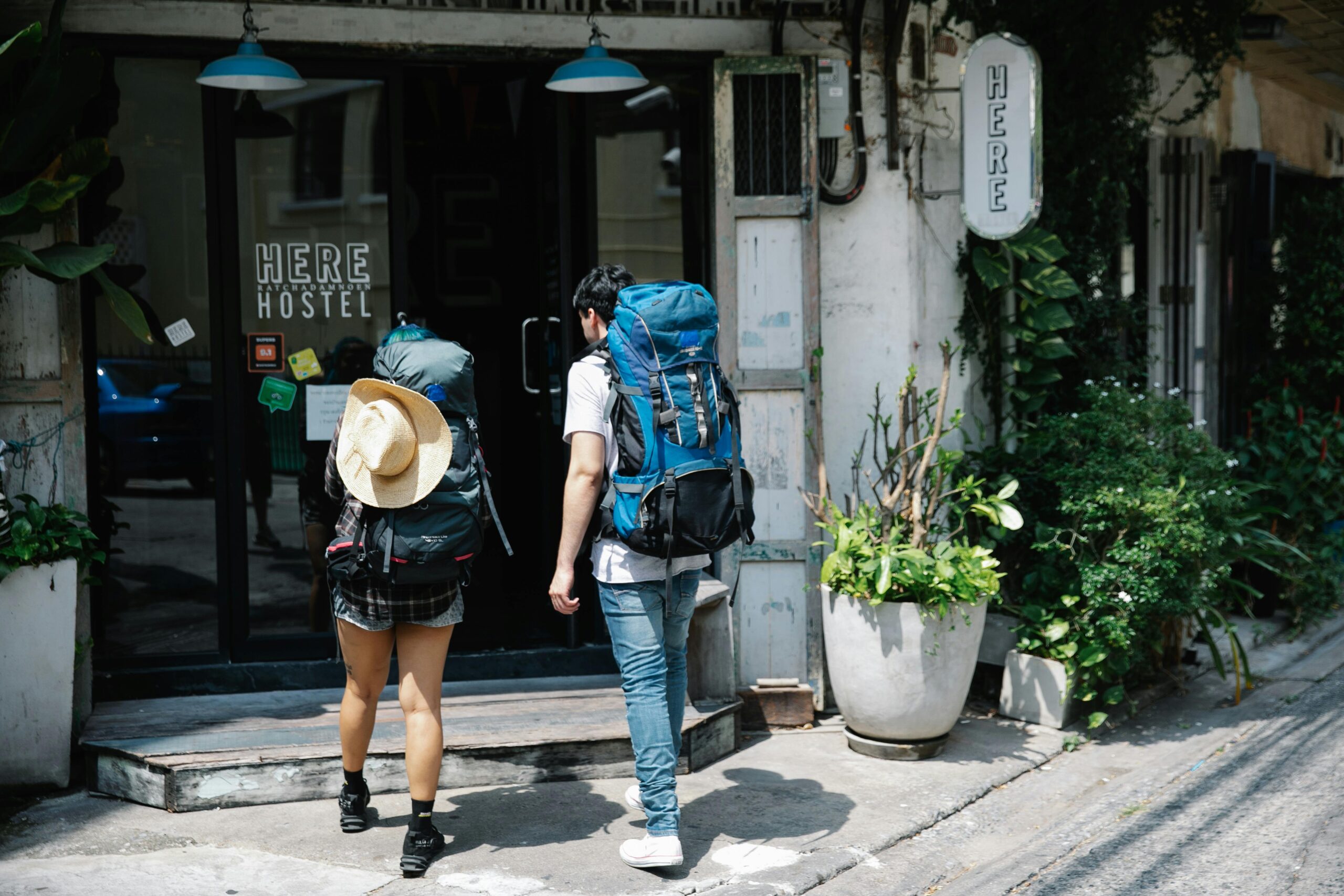 2 backpacking travelers entering a hostel